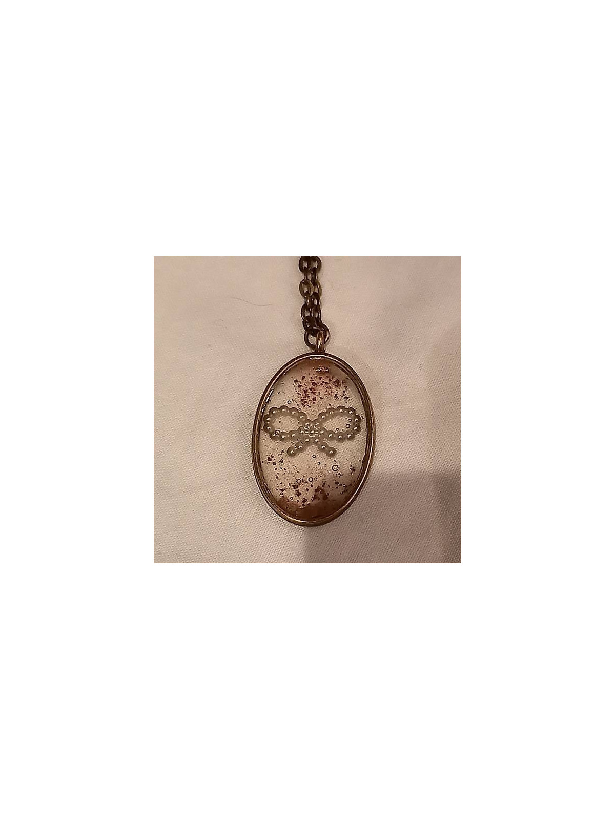 Collier ovale de résine avec noeud nacré