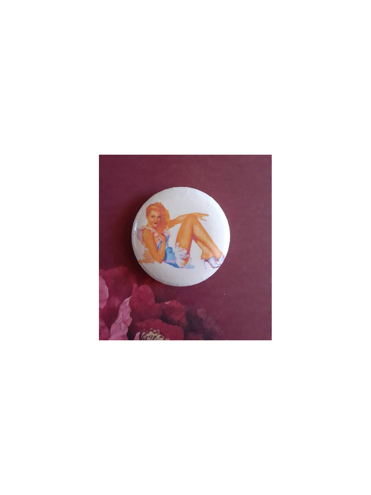Badge pin-up semi couchée blonde avec robe bleue