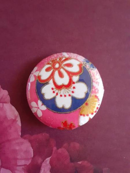 Badge papier origami boule bleue sur fond rose