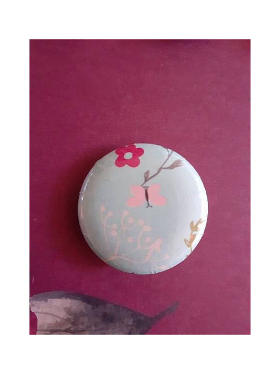 Badge papillon rose et fleur blanche sur fond bleu