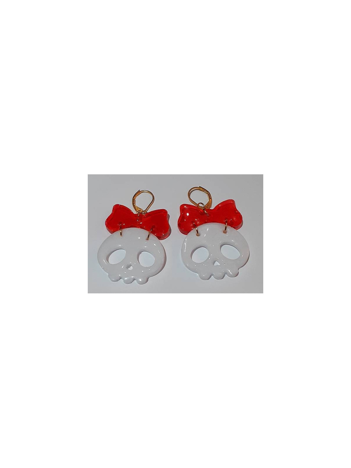 La paire de boucle d'oreilles  cranes blancs et noeuds en résine est disponible à Ciel rouge Dijon