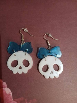 La paire de boucle d'oreilles  cranes blancs et noeuds en résine est disponible à Ciel rouge Dijon