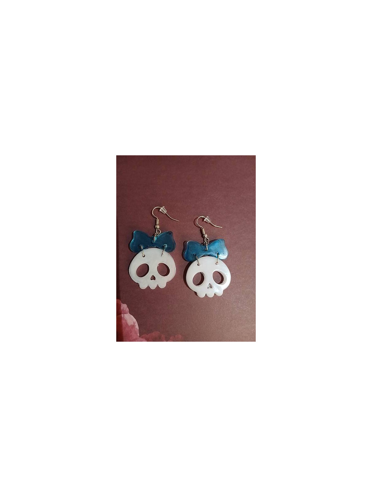 La paire de boucle d'oreilles  cranes blancs et noeuds en résine est disponible à Ciel rouge Dijon